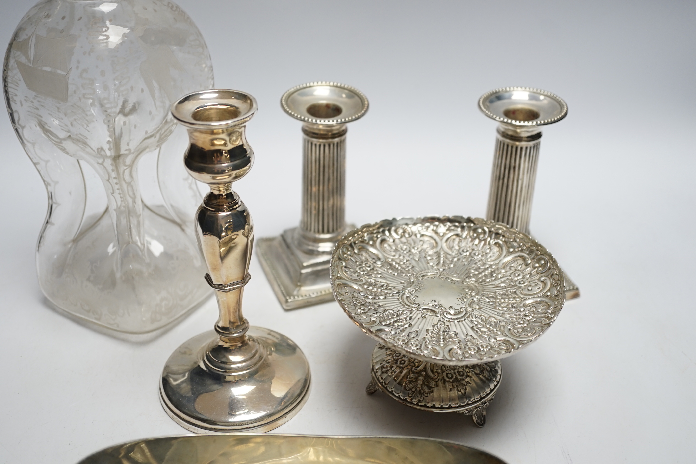 A pair of late Victorian silver mounted dwarf candlesticks, (a.f.)12.8cm, one other candlestick, a silver tazze, silver oval dish and a silver mounted glass decanter (lacking stopper).